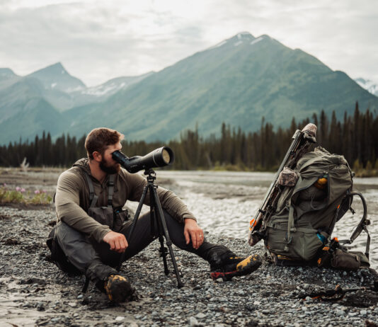 The Next Level in Optics with Ryan Holm of Leica Man looks through Leica spotting scope in the mountains on a hunt